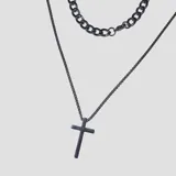 Collar doble color negro compuesto por una cadena de eslabones gruesos y una cadena más fina con dije de cruz.
