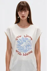 Remera negra de algodón, con cuello redondo, mangas cortas holgadas con vuelta y estampa floral grande en el pecho.