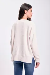 Buzo de tejido de punto chenille en color crudo, con cuello redondo, mangas largas y puños acanalados. Presenta un diseño de textura combinada con paneles laterales de tejido liso y frente con textura de punto fantasía.