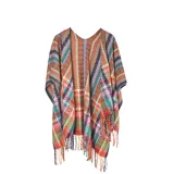 Poncho abierto de tejido de punto con diseño de rayas horizontales multicolor y patrones geométricos. Presenta terminaciones con flecos en el ruedo.