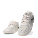 Championes urbanos Umbro modelo Milo, con diseño de paneles en tonos beige y blanco, y detalles en azul marino en el talón y logo lateral. Presenta puntera perforada y suela de goma al tono.