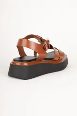 Sandalias negras de plataforma con tiras de símil cuero texturizado y hebilla metálica ajustable.