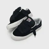 Zapatillas urbanas de corte bajo en color negro, fabricadas en gamuza con suela de goma blanca, cordones gruesos negros y etiqueta con logo en la lengüeta.