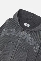 Campera con capucha de tejido de punto acanalado en color gris oscuro con efecto lavado. Presenta cierre frontal completo con tirador circular, bolsillos tipo canguro y logo bordado en relieve en el pecho. Posee terminaciones con bordes deshilachados en puños y ruedo.