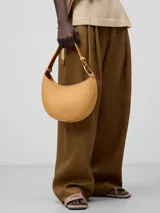 Bolso de hombro Adolfo Dominguez modelo Luna, con diseño de media luna y textura granulada. Cuenta con un compartimento principal con cierre de cremallera y asa corta regulable con detalle metálico.