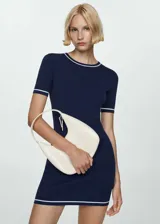 Vestido corto de punto fino en color azul marino, con diseño entallado, cuello redondo y mangas cortas. Presenta detalles de líneas blancas en contraste en el cuello, los puños y el ruedo.
