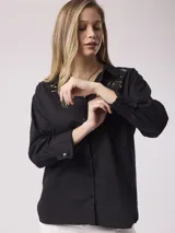 Camisa negra de algodón con cuello clásico y bordados calados en el canesú.