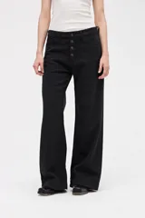 Jean de corte wide leg en color negro, con tiro medio y cierre frontal con botones a la vista. Presenta un diseño holgado desde la cadera hasta el bajo, con pierna ancha.