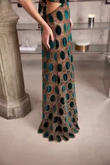 Vestido largo de encaje con diseño de círculos de terciopelo verde, con escote halter que se ata en la nuca y espalda descubierta con ajuste en la cintura.