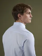 Camisa celeste de corte clásico, confeccionada en tela Oxford de algodón. Tiene cuello abotonado, manga larga con puños abotonados y bolsillo en el pecho. Marca Mersey.