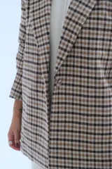 Blazer de corte recto con estampado a cuadros en tonos beige y marrón, con solapas clásicas y cierre frontal.