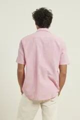 Camisa sport de manga corta, confeccionada en una mezcla de lino y algodón. Presenta cuello clásico, cierre frontal con botones de coco y un bolsillo aplicado en el pecho.