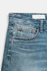 Bermuda de tiro medio confeccionada en denim de color negro gastado, con diseño de cinco bolsillos, trabillas para cinturón y cierre frontal con cremallera y botón metálico.