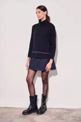 Sweater negro de cuello alto con tajos laterales y detalle de línea plateada en puños y ruedo.