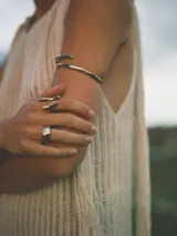 Anillo plateado con diseño abstracto y abierto, realizado en alpaca.