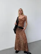 Vestido largo ajustado de microtul elastizado, con estampado de leopardo en tonos marrón y negro. Presenta escote drapeado tipo cowl neck y tirantes finos ajustables.