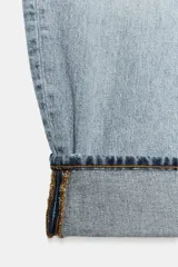 Jeans de tiro medio con diseño de pierna tipo balloon y corte full length. Presenta cintura con trabillas, cinco bolsillos clásicos, cierre frontal con cremallera y botón, y bajo acabado con vuelta.
