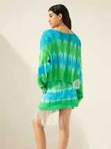 Minifalda de tejido de red teñida con técnica batik en tonos verde y celeste, con flecos y canutillos en un lateral.