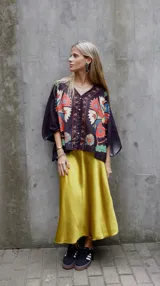 Falda midi evasé de raso color negro, con cintura elástica y cinturón con apliques metálicos.