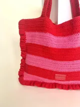 Bolso tipo tote tejido a crochet con hilo de algodón color marrón y crudo, con diseño a rayas horizontales y volados en los bordes.