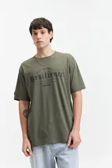 Remera verde militar de manga corta y escote redondo, con estampado frontal que dice "ORIGINAL RESILIENCE THE WORLD HAS CHANGED ESTABLISHED SINCE 1976 // NLD mistral".