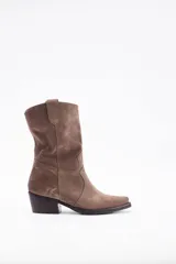Bota corta estilo western confeccionada en cuero descarne color marrón, con taco cuadrado de madera y punta ligeramente afinada.