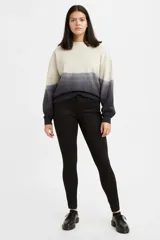 Jean de corte super skinny, tiro medio y color negro sólido. Presenta un diseño clásico de cinco bolsillos con cierre de cremallera y botón metálico.