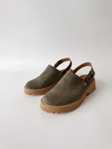 Zuecos de cuero color verde seco, con hebilla lateral y suela de goma.