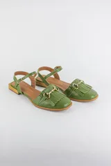 Sandalias de cuero color celeste, con punta cerrada, flecos frontales y detalle de estribo metálico dorado. Tienen tira ajustable al tobillo y suela plana con pequeño taco.