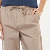 Pantalón de vestir color beige, de corte recto, con cintura elástica ajustable con cordón.