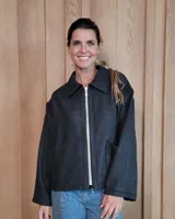 Chaqueta de textura bouclé en color bordó, con corte oversize, cuello camisero, cierre frontal y bolsillos laterales.