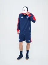 Gorra Trucker Umbro del Club Nacional de Football, modelo Elite. Diseño combinado en rojo y azul marino, con red trasera y visera curvada bicolor. Incluye el logo de Umbro y la palabra 'Nacional' bordados en el frente.
