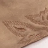 Cartera tipo hobo color beige con flecos laterales, detalle de bordado en la parte inferior frontal y bolsillo trasero con cierre. Cuenta con asa corta de hombro y correa extraíble.