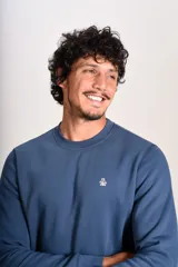 Buzo de cuello redondo en color azul, con diseño liso y logo bordado pequeño en el pecho. Presenta puños y ruedo acanalados.