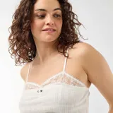 Camiseta de tirantes color blanco, con tejido de punto calado, detalles de encaje en el escote y tirantes finos regulables.