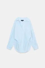 Camisa de corte oversize con estampado de rayas verticales en tonos celeste y blanco. Presenta cuello solapa, escote en pico, manga larga con puños abotonados y un bolsillo de plastrón en el pecho.