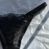 Conjunto de lencería de encaje compuesto por un soutiene con aro y detalles de moños pequeños en el centro.