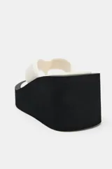 Sandalias de plataforma color negro, con diseño de tira de dedo y suela alta tipo cuña.