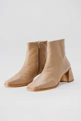 Botas plateadas de cuero con caña media, cierre lateral con cremallera, punta cuadrada y tacón geométrico de madera.