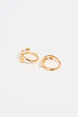 Par de aros de metal dorado con forma de aro grueso y textura irregular.