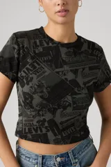 Remera crop de corte ajustado con estampado gráfico integral de estilo vintage con logotipos y tipografía de la marca Levi's en tonos negros y grises.