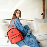 Mochila color topo de neopreno con cierres negros, asa de mano y correas regulables.