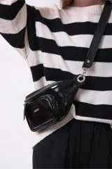 Sweater de tejido de punto con diseño de rayas horizontales anchas en color negro y crema, de corte holgado, cuello redondo y mangas largas.