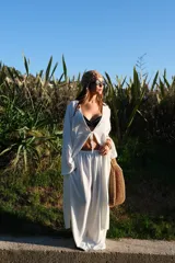 Pantalón de corte amplio y tiro medio, confeccionado en tela crepe color beige, con diseño fluido y holgado.