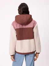 Campera con capucha de diseño combinado en bloques de color. Presenta una sección superior en pana rosada, una franja central en nylon marrón con logo de la marca y cuerpo inferior y mangas en tejido sherpa color crema. Incluye cierre frontal y bolsillos laterales.