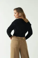 Sweater negro de punto con diseño trenzado, corte cropped, cuello redondo y mangas largas.