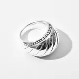Anillo plateado con diseño abovedado y textura acanalada.