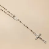Rosario de plata 925 compuesto por cuentas esféricas pulidas, una medalla central con imagen religiosa y un crucifijo detallado en el extremo.