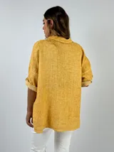 Camisa color salmón de lino, de corte recto, con cuello clásico, cierre frontal con botones y mangas 3/4 con trabilla.