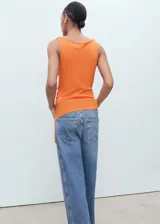 Top de punto fino color naranja, sin mangas, con cuello drapeado y bajo asimétrico.